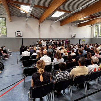 Menschen auf Veranstaltung in Sporthalle einer Schule